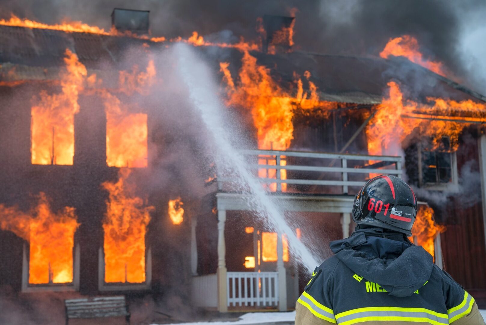 A fireman is spraying water on a fire.