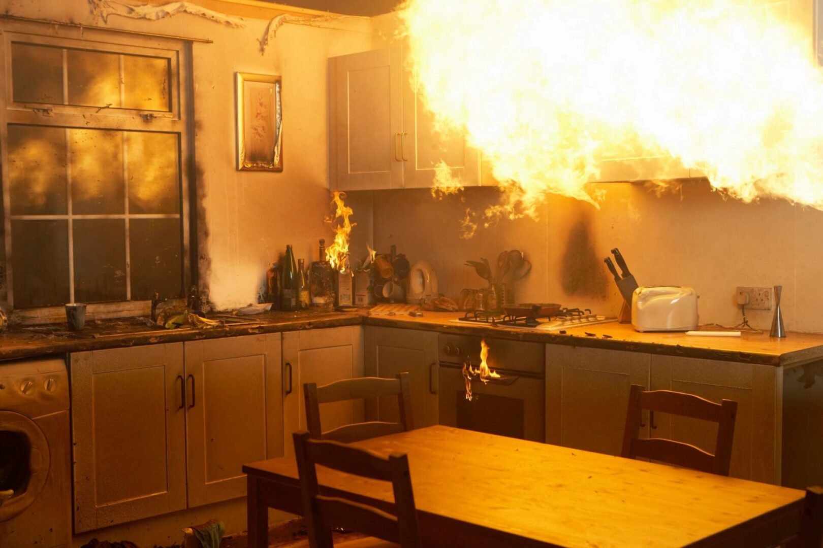 A kitchen with flames coming from the oven.