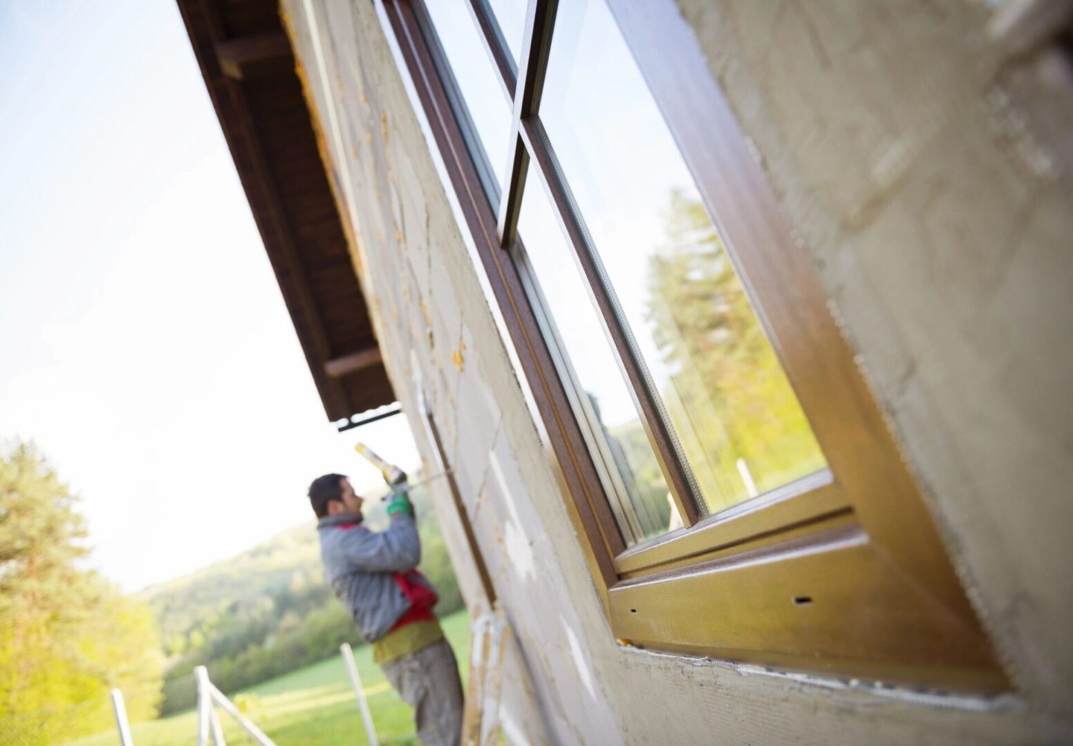 A man is working on the outside of a house.