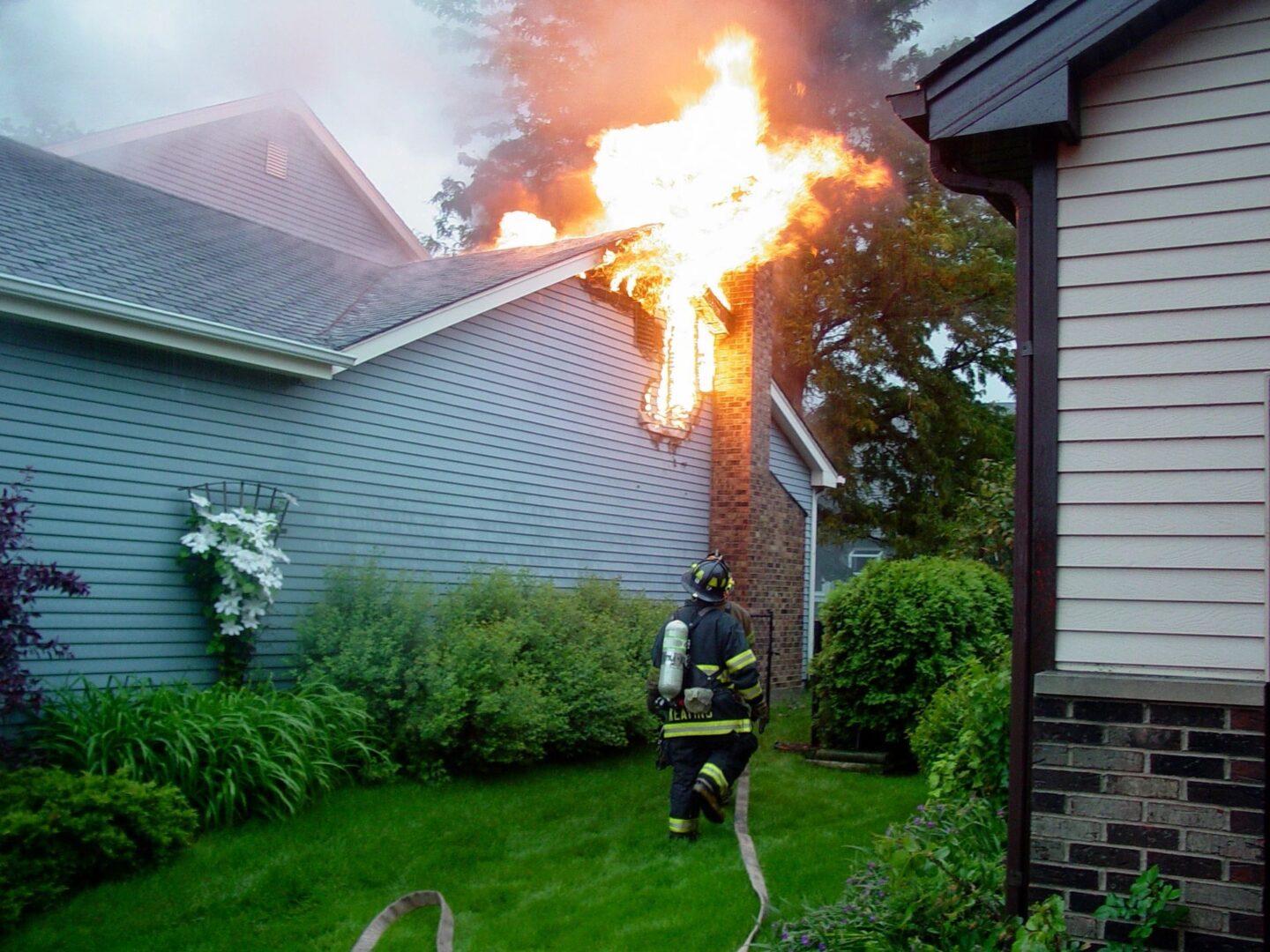 A fireman is in the yard of a house