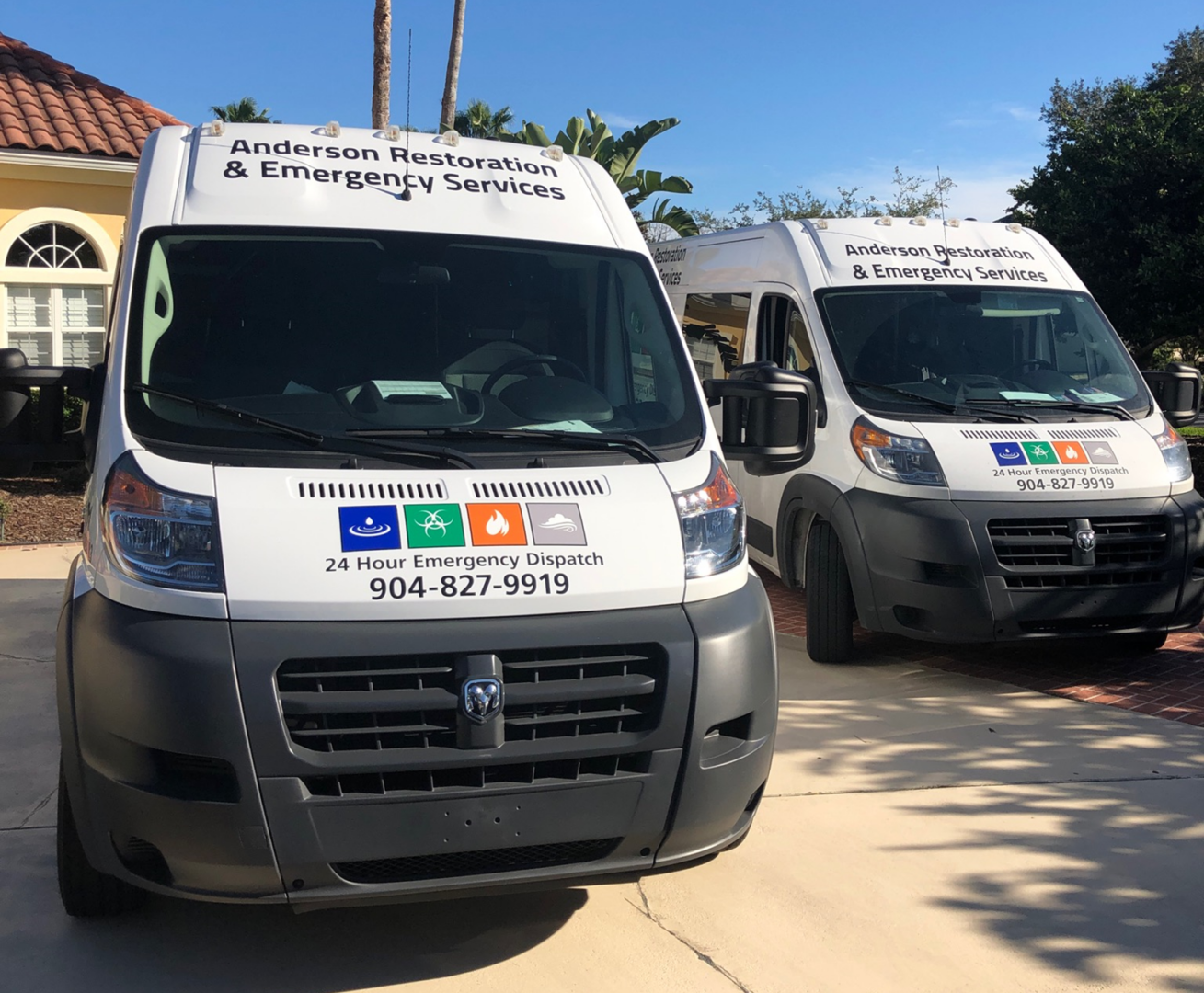 Two white vans parked on the side of a road.