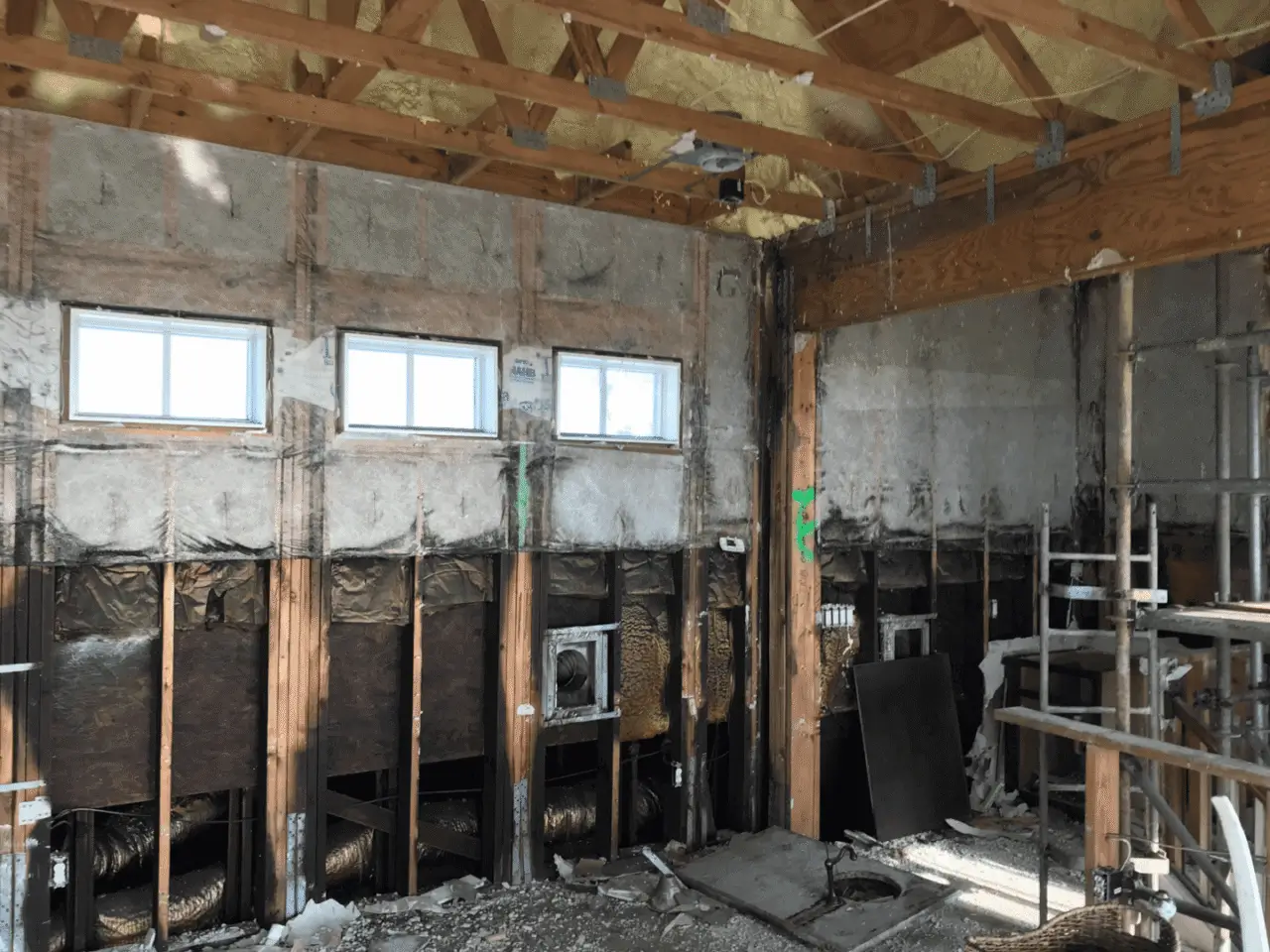 Fire-damaged interior with exposed wooden beams.